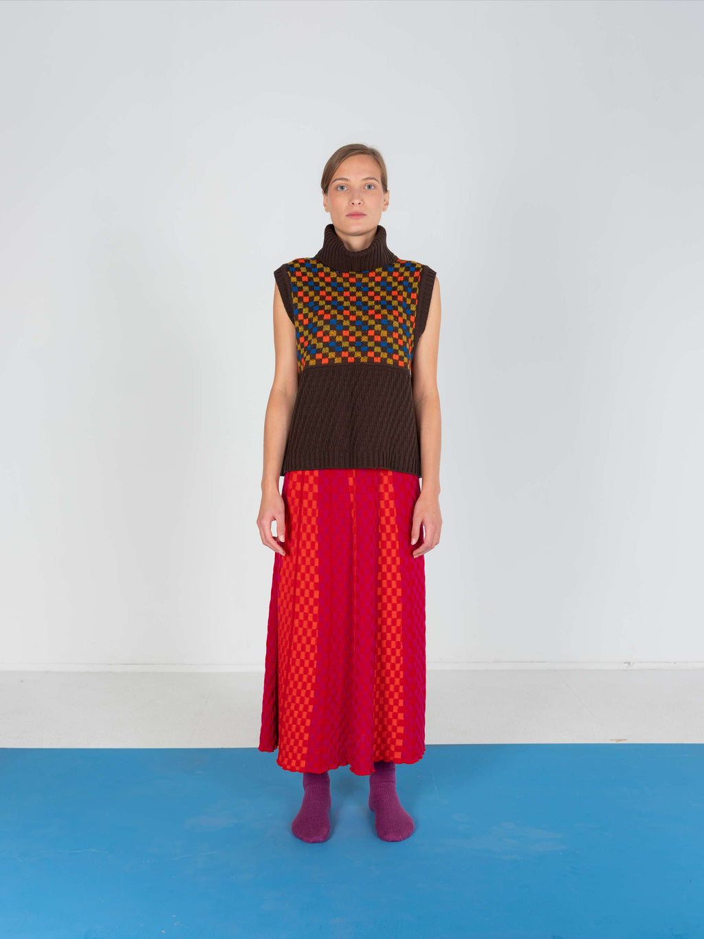 Product view of the Red Checkered Wavy Skirt, knitted skirt in a red-accented, wavy textured checkered plated pattern. By JONA BEDNJANEC.