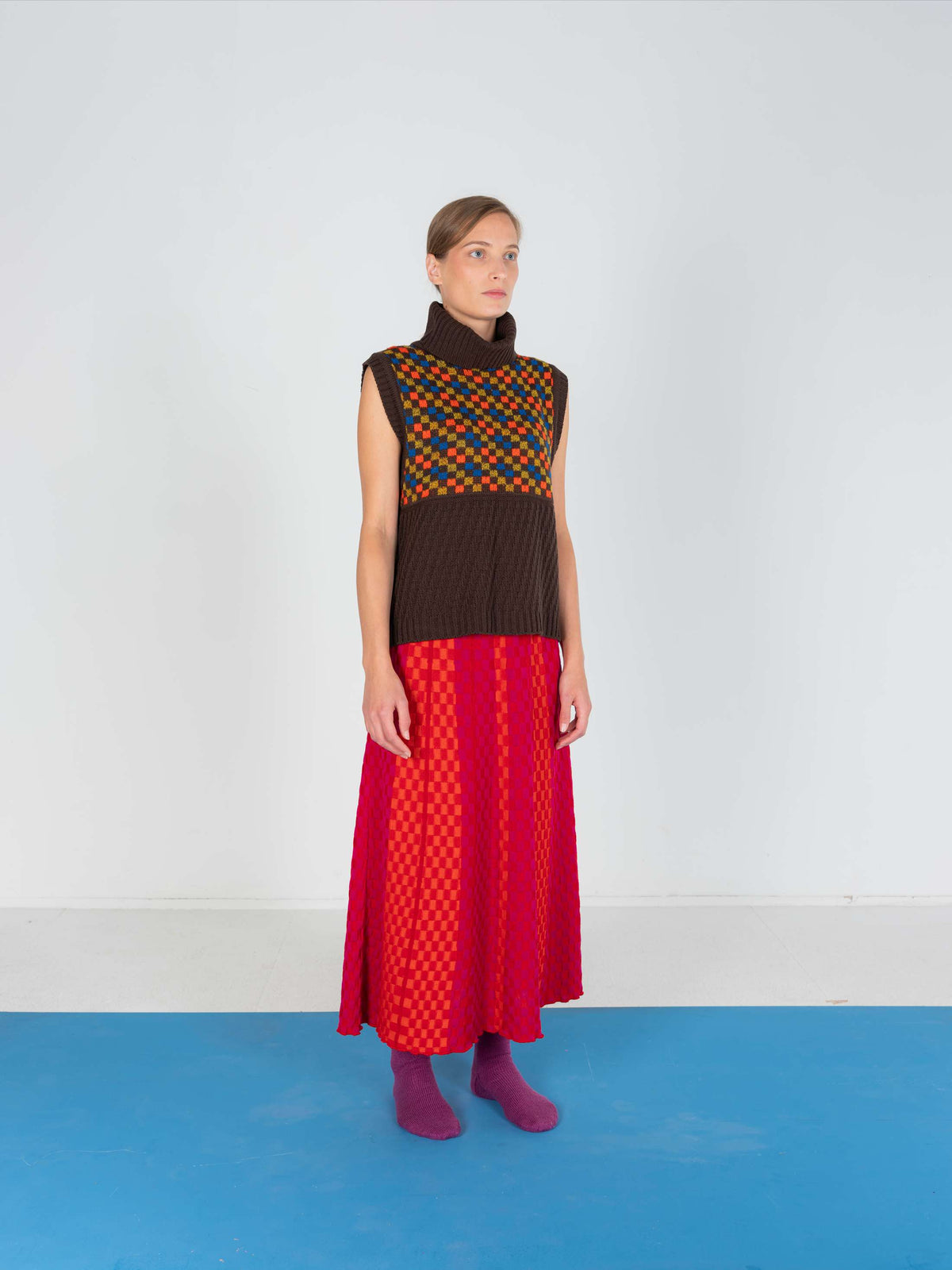 Product view of the Red Checkered Wavy Skirt, knitted skirt in a red-accented, wavy textured checkered plated pattern. By JONA BEDNJANEC.