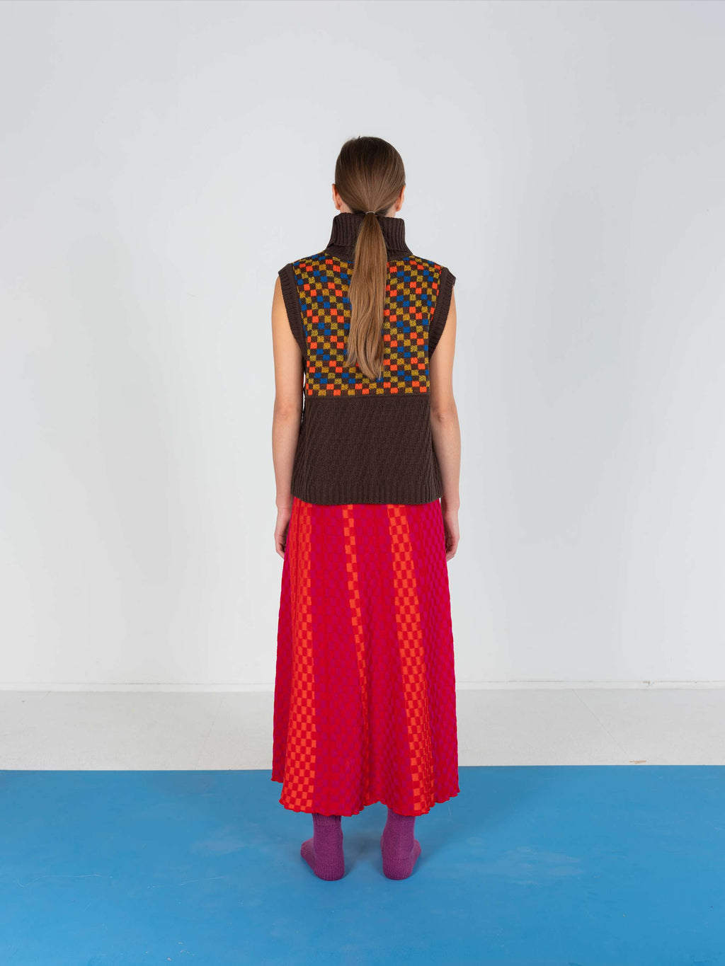 Product view of the Red Checkered Wavy Skirt, knitted skirt in a red-accented, wavy textured checkered plated pattern. By JONA BEDNJANEC.
