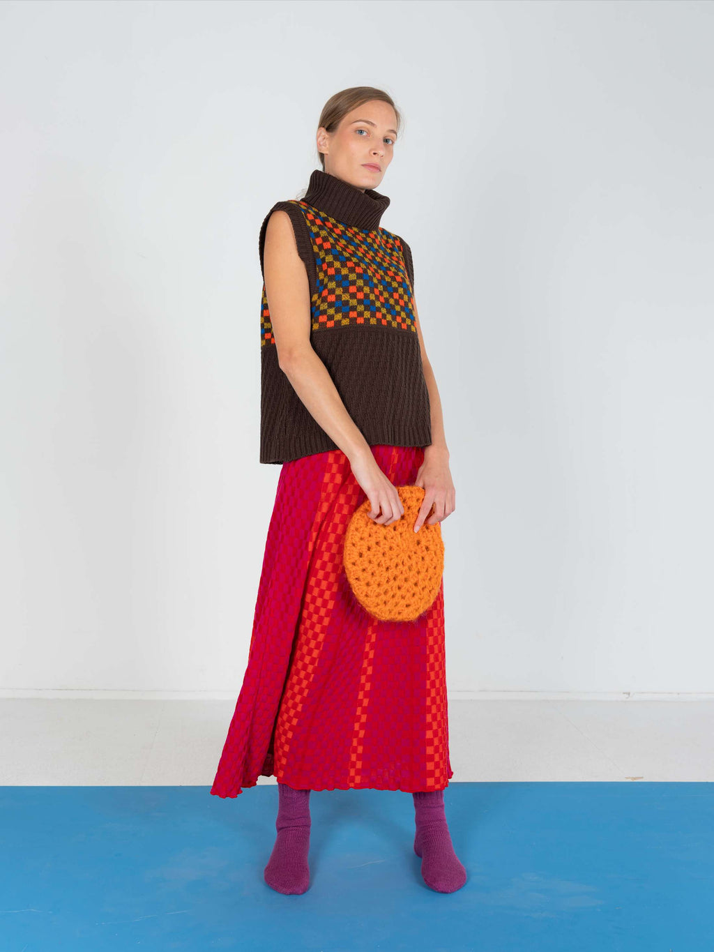 Product view of the Red Checkered Wavy Skirt, knitted skirt in a red-accented, wavy textured checkered plated pattern. By JONA BEDNJANEC.