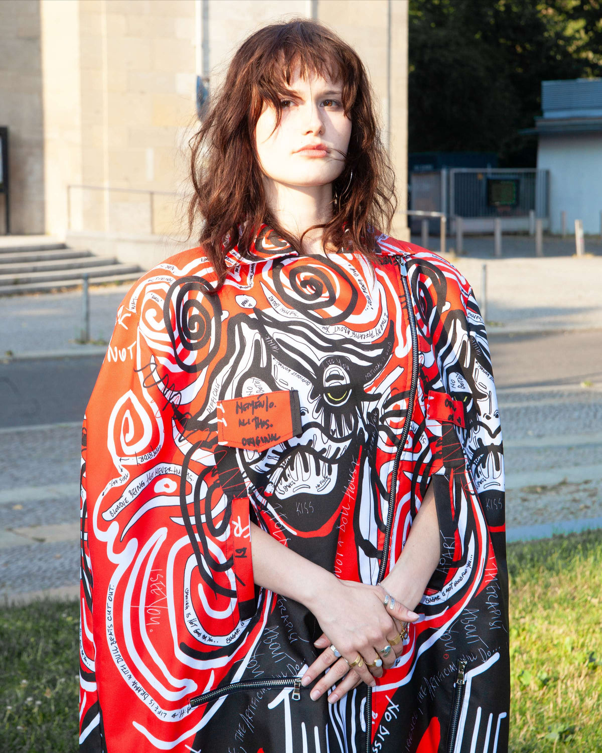 Product view of the The Misfit 3-in-1, convertible waterproof Oxford piece with a red, white and black print. By MemenTo.